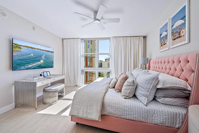 a bedroom with a large bed a flat screen tv and couches