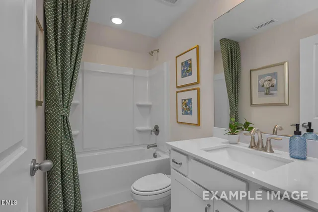 a bathroom with a granite countertop sink a toilet and shower