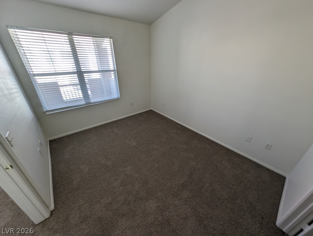 10550 West Alexander Road, Unit 2117 Las Vegas, NV 89129 - Photo 14 of 24 Plush wall-to-wall carpeting and neutral walls define this versatile secondary bedroom space.