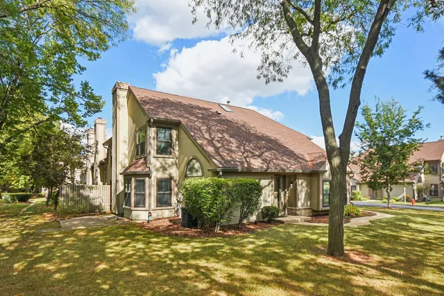 a view of a house with a tree in front of it