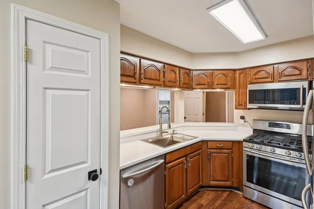 a kitchen with stainless steel appliances granite countertop a sink stove and microwave
