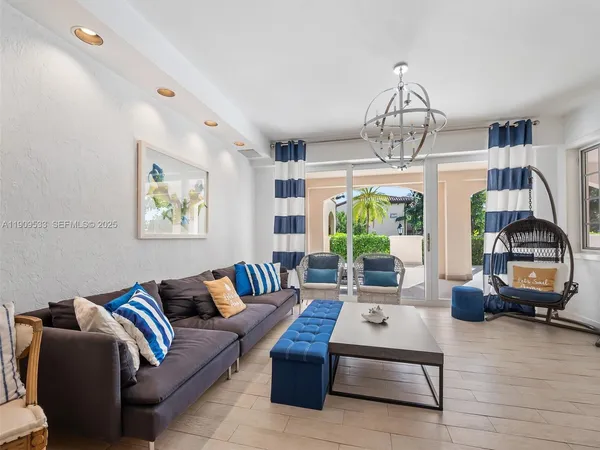 a living room with furniture chandelier and a large window