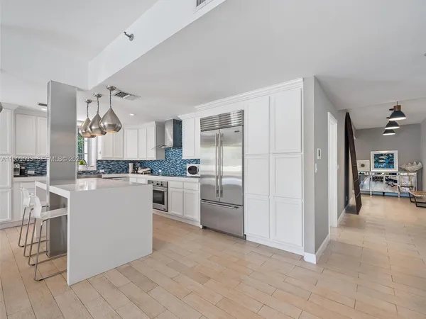 a kitchen with white cabinets and counter space