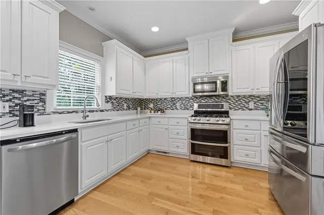 a kitchen with cabinets stainless steel appliances and window