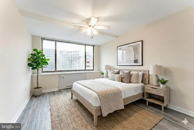 a bedroom with a large bed lamp and a potted plant