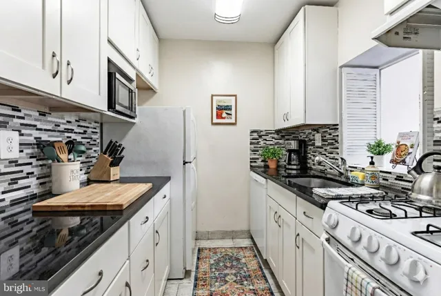 a kitchen with stainless steel appliances a stove a sink and a refrigerator