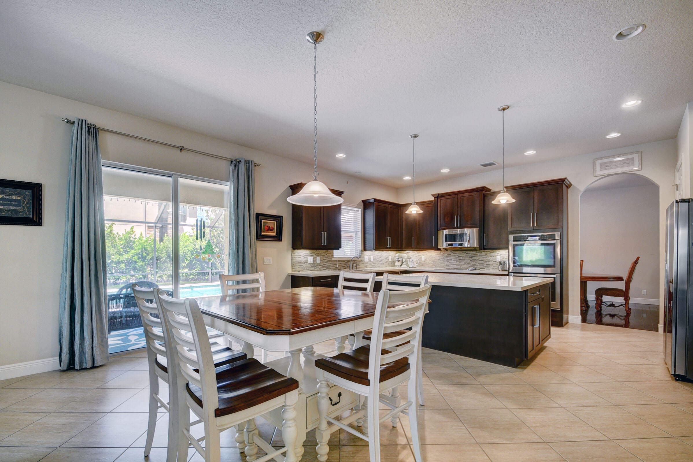 8625 Wellington View Drive Royal Palm Beach, FL 33411 - Photo 15 of 54 a kitchen with a table and chairs in it