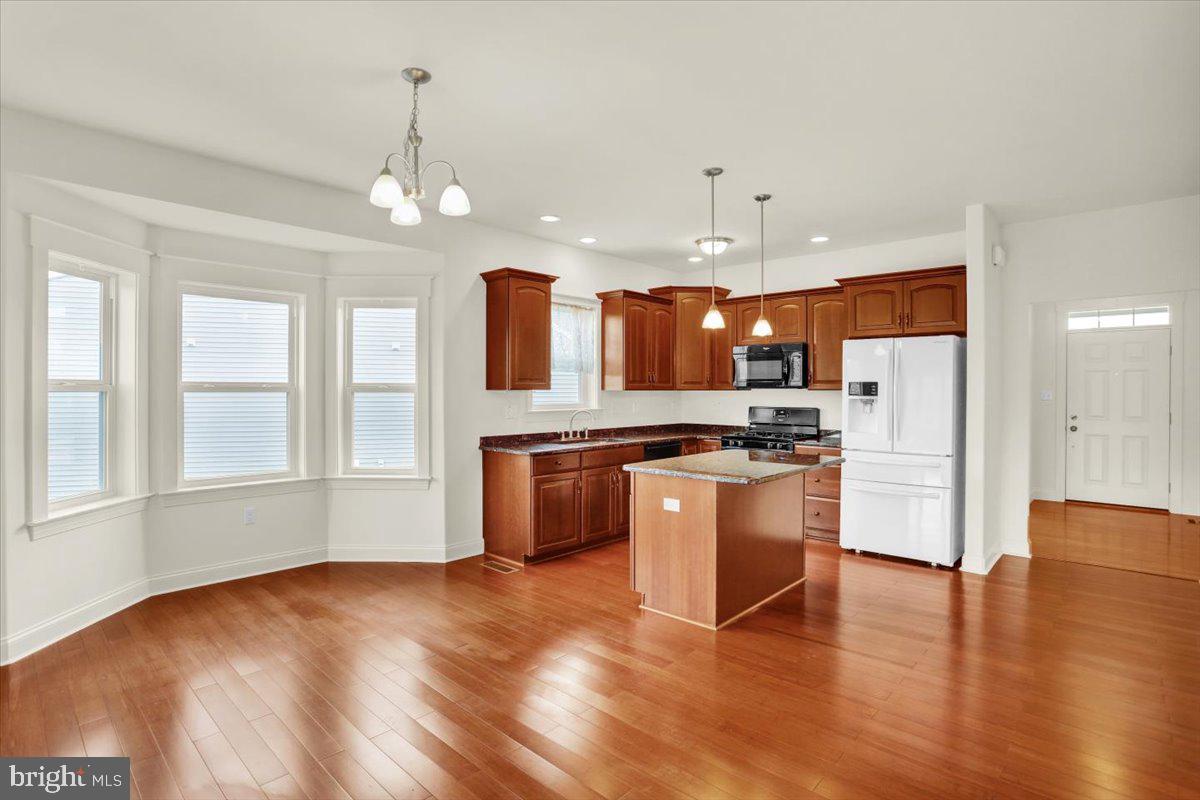 28 Calming Trail Sinking Spring, PA 19608 - Photo 12 of 43 a large kitchen with granite countertop a large kitchen island a sink dishwasher a refrigerator and white cabinets with wooden floor