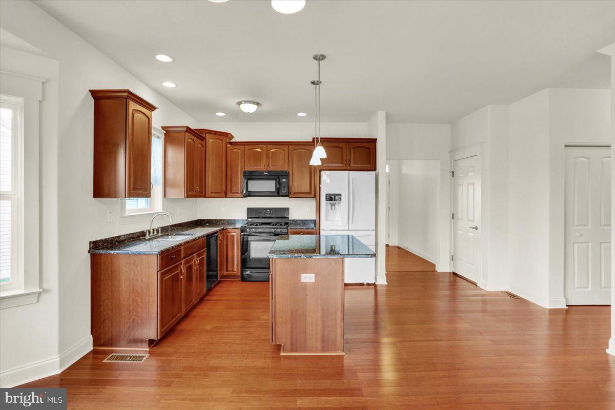 28 Calming Trail Sinking Spring, PA 19608 - Photo 13 of 43 a kitchen with stainless steel appliances granite countertop a refrigerator a stove top oven a sink dishwasher and wooden cabinets with wooden floor