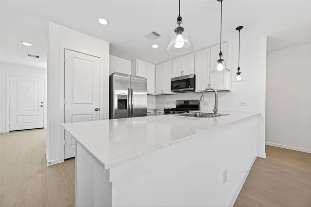 a large kitchen with kitchen island a sink stainless steel appliances and cabinets