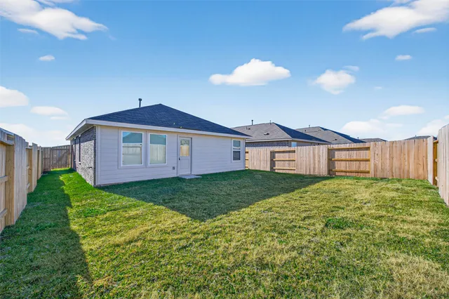 a view of a yard in front of a house with a large tree