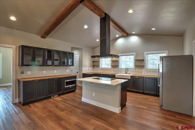 a kitchen with stainless steel appliances kitchen island granite countertop a stove and a sink
