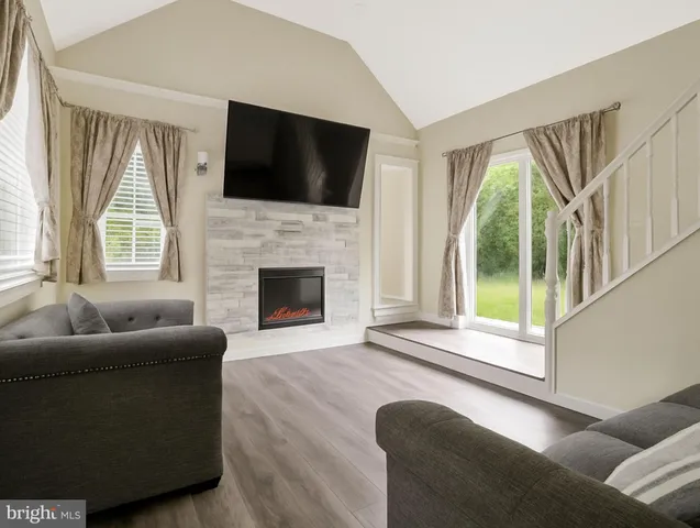 a living room with furniture a flat screen tv and a fireplace