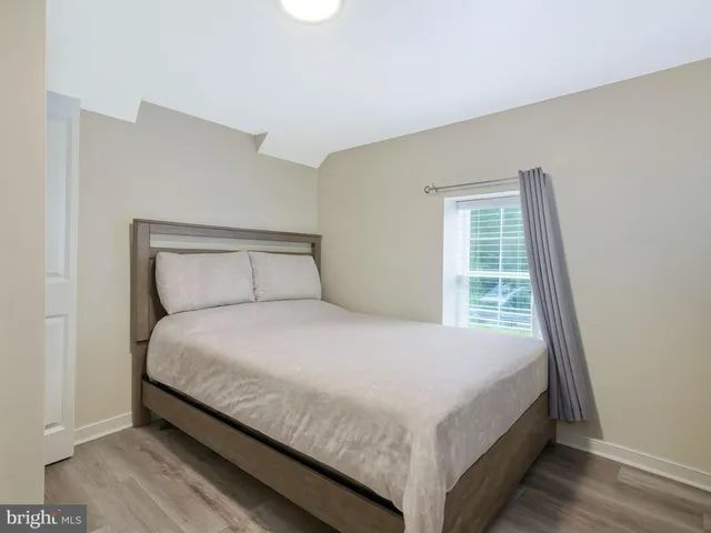a large bed sitting in a bedroom next to a window
