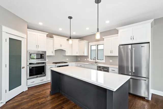 a kitchen with kitchen island a sink stainless steel appliances and cabinets