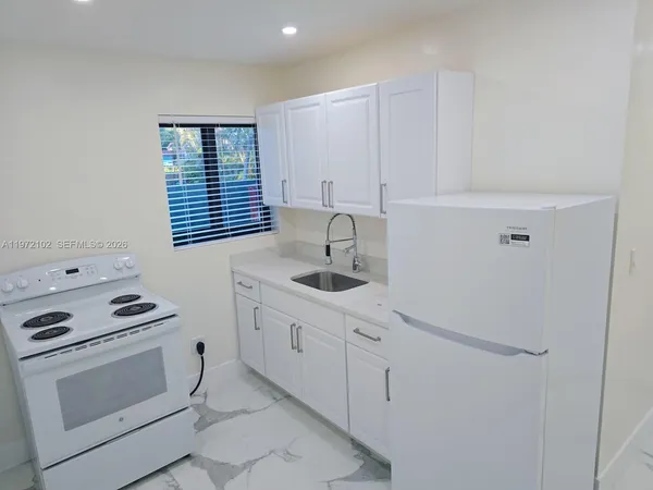 a kitchen with stainless steel appliances a sink stove and cabinets