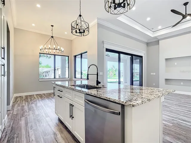 a kitchen with granite countertop stainless steel appliances a sink and stove