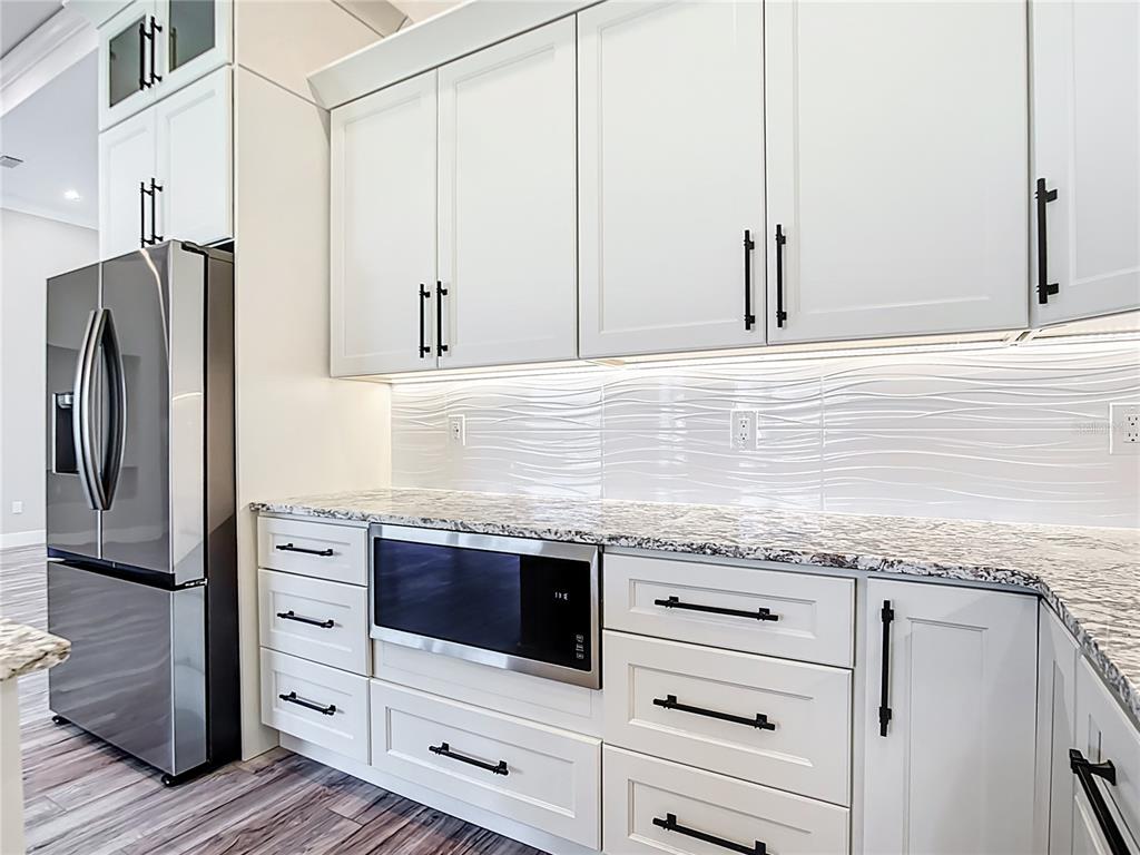 10588 Kidron Avenue Englewood, FL 34224 - Photo 12 of 53 a kitchen with granite countertop a sink and dishwasher a refrigerator with wooden cabinets