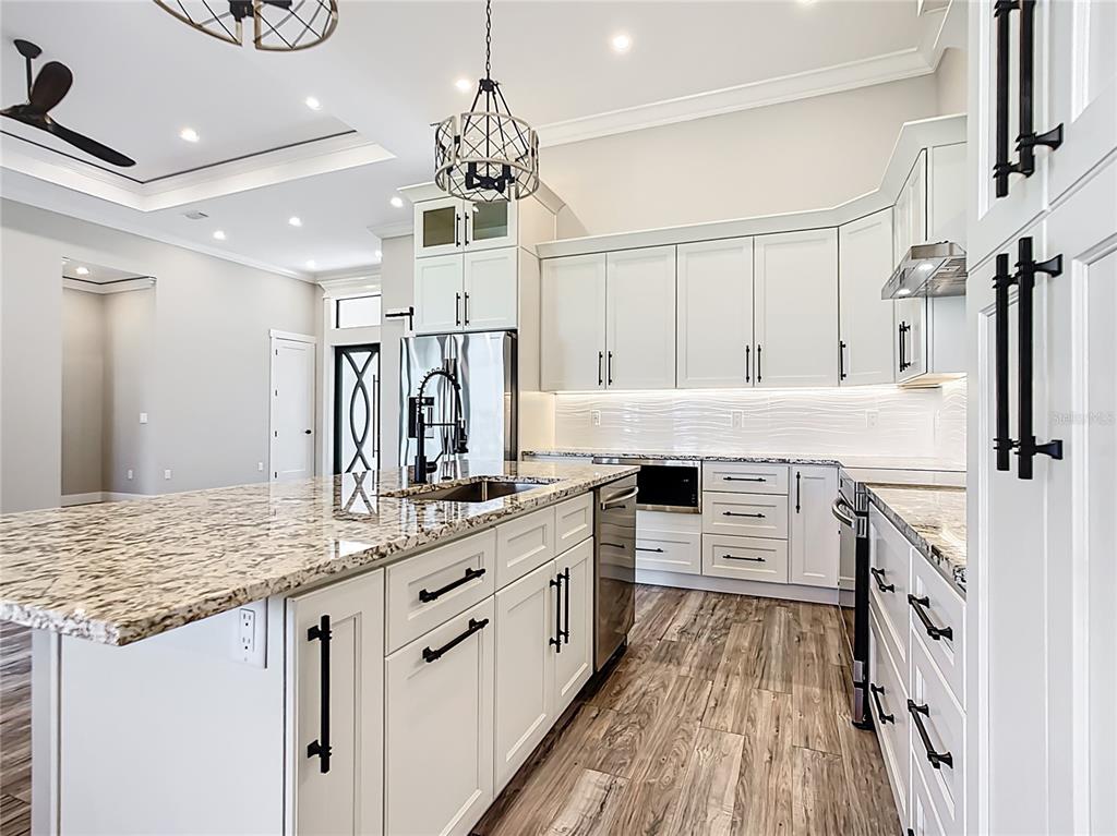 10588 Kidron Avenue Englewood, FL 34224 - Photo 13 of 53 a kitchen with stainless steel appliances kitchen island granite countertop a stove refrigerator and cabinets