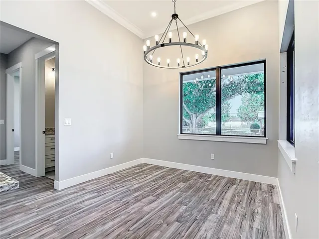 a view of a room with wooden floor chandelier and window