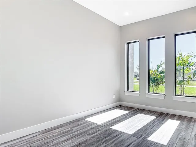 a view of an empty room with wooden floor and closet