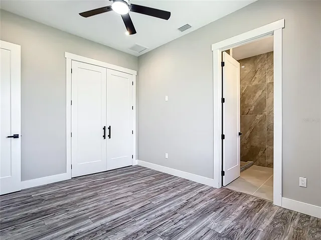 a bathroom with a granite countertop toilet sink and mirror