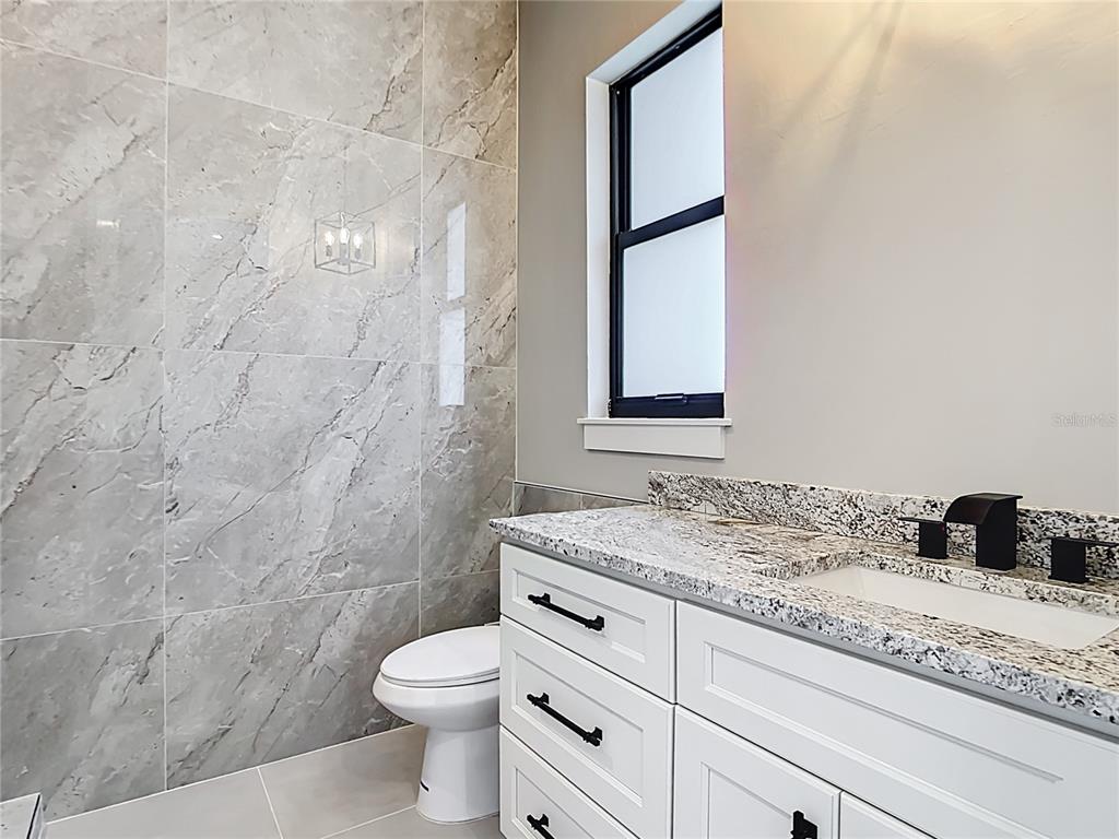 10588 Kidron Avenue Englewood, FL 34224 - Photo 40 of 53 a bathroom with a granite countertop sink toilet and shower