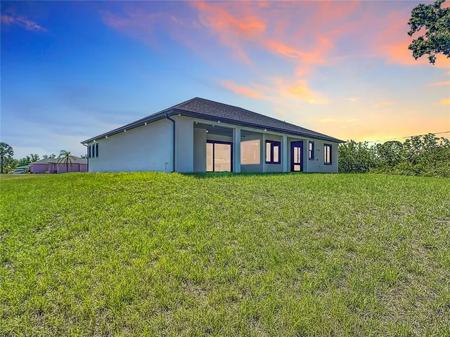 an aerial view of residential houses with outdoor space and trees