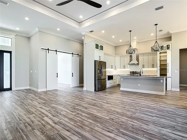 a view of a kitchen with refrigerator a stove and wooden floor
