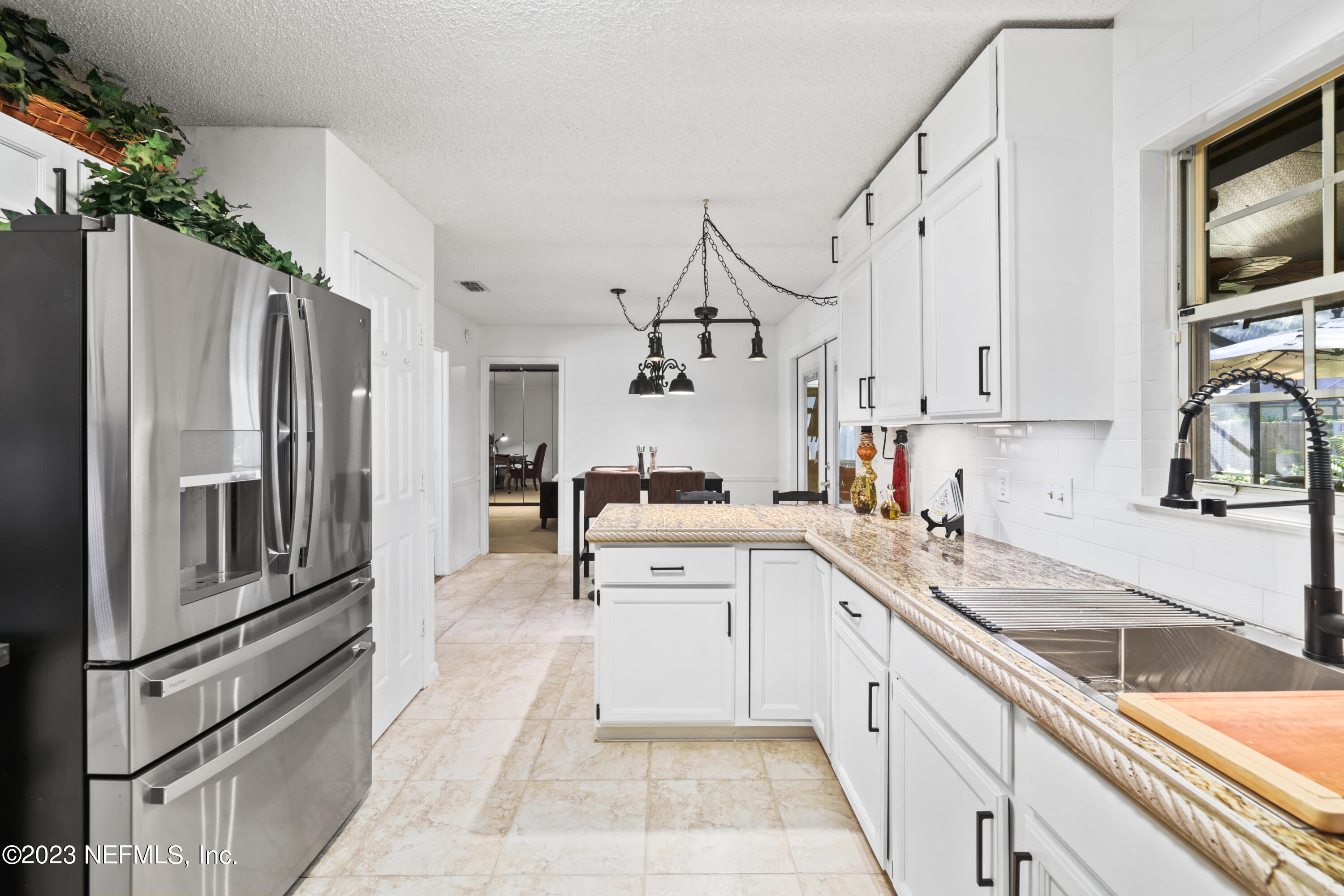10954 Heathfield Road Jacksonville, FL 32225 - Photo 11 of 42 a kitchen with white cabinets and stainless steel appliances