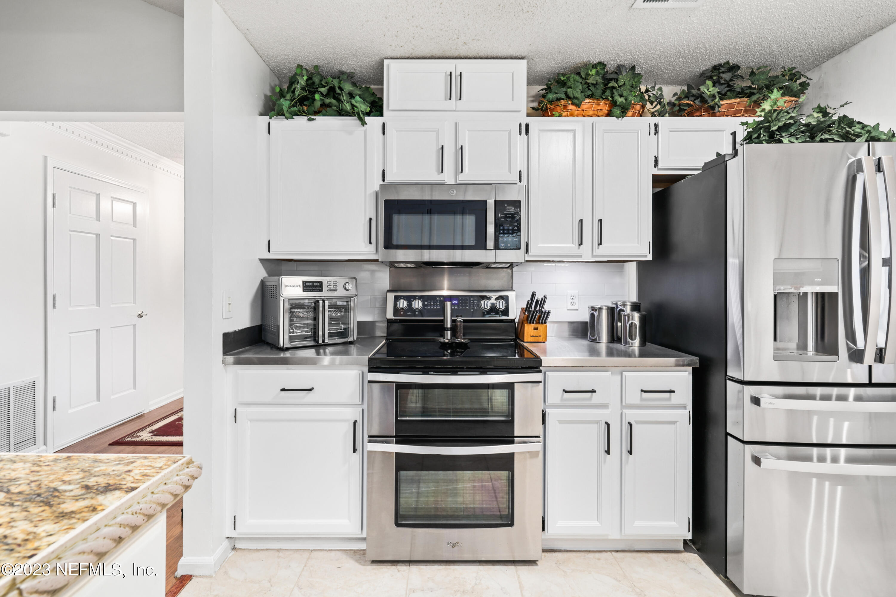 10954 Heathfield Road Jacksonville, FL 32225 - Photo 13 of 42 a kitchen with stainless steel appliances white cabinets and a stove top oven