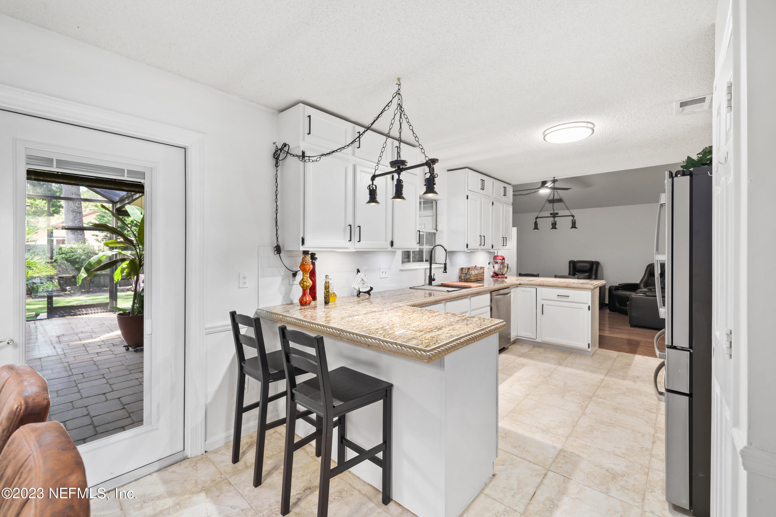 10954 Heathfield Road Jacksonville, FL 32225 - Photo 14 of 42 a kitchen with stainless steel appliances kitchen island a table chairs in it and wooden floors