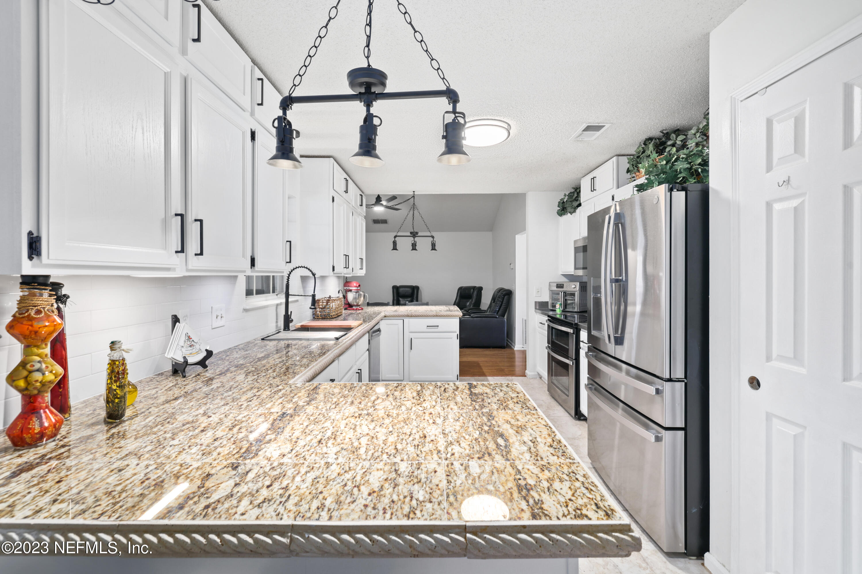 10954 Heathfield Road Jacksonville, FL 32225 - Photo 16 of 42 a kitchen with stainless steel appliances granite countertop a refrigerator and a stove top oven