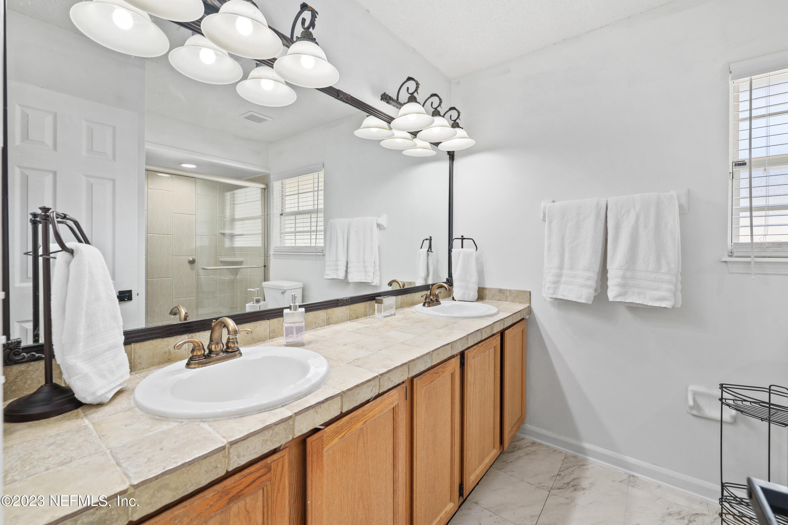10954 Heathfield Road Jacksonville, FL 32225 - Photo 24 of 42 a bathroom with a sink vanity and a mirror