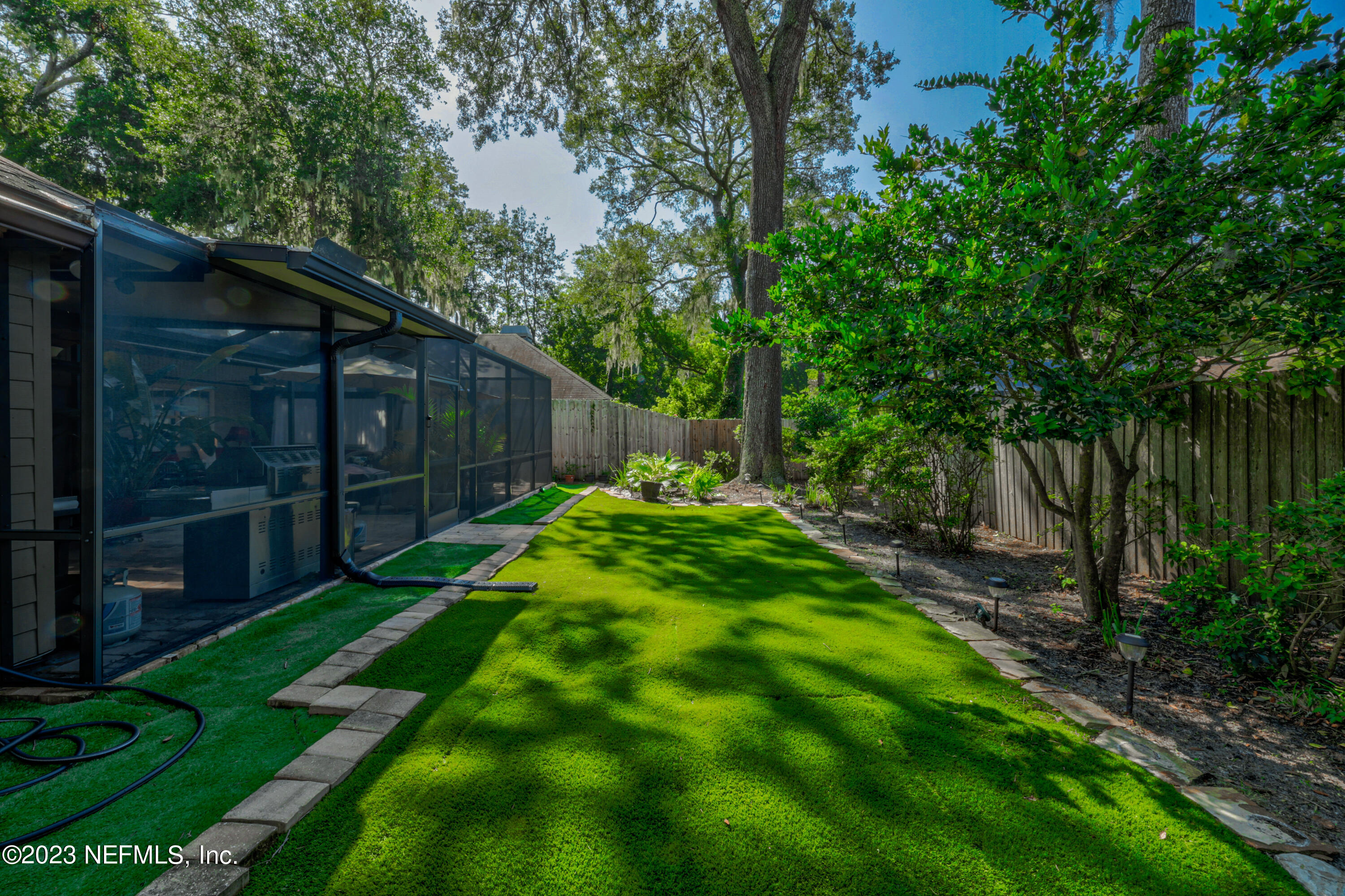 10954 Heathfield Road Jacksonville, FL 32225 - Photo 42 of 42 a view of a backyard with large trees and wooden fence