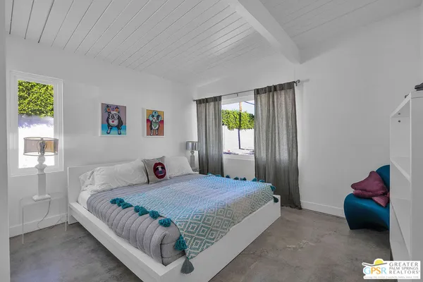 a bedroom with a bed and a painting on the wall
