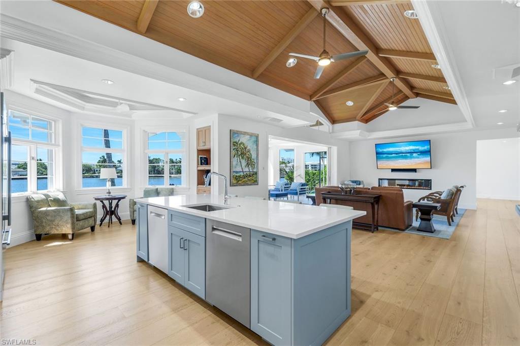 400 Springline Drive Naples, FL 34102 - Photo 36 of 37 Kitchen with open floor plan, light wood finished floors, light stone countertops, recessed lighting, and a center island with sink