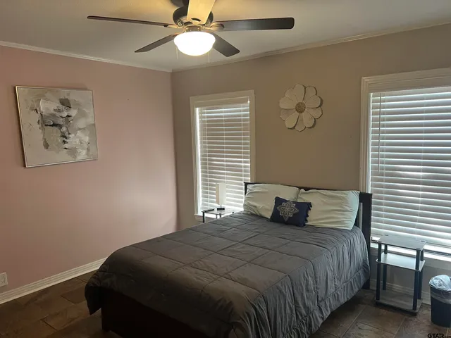 a bedroom with a large bed and a chandelier