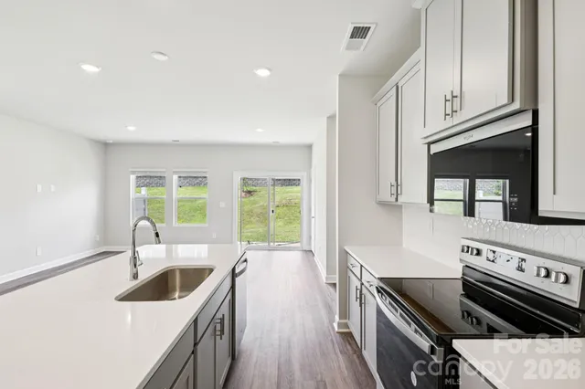 a kitchen with granite countertop a stove a sink and a cabinets