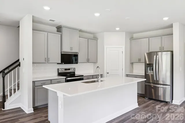 a kitchen with stainless steel appliances a refrigerator sink and microwave