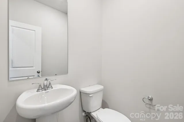 a bathroom with a sink a toilet and mirror