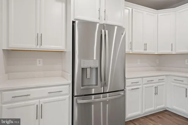 a kitchen with white cabinets and white appliances
