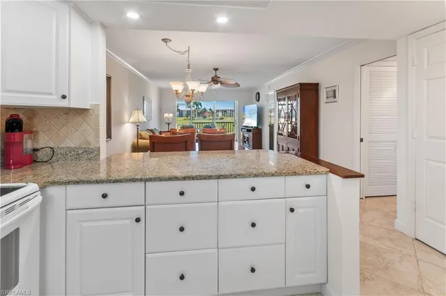 a kitchen with granite countertop white cabinets and stainless steel appliances
