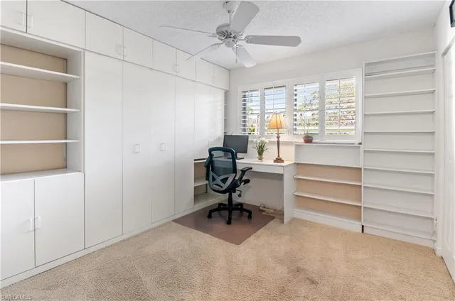 a view of a workspace with furniture and a window