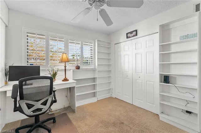 a view of a workspace with furniture and a window