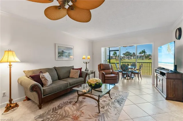 a living room with furniture a flat screen tv and a large window