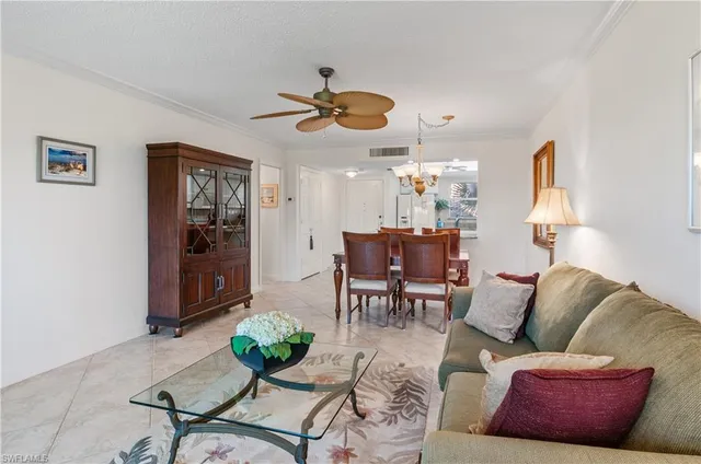 a living room with furniture kitchen view and a chandelier