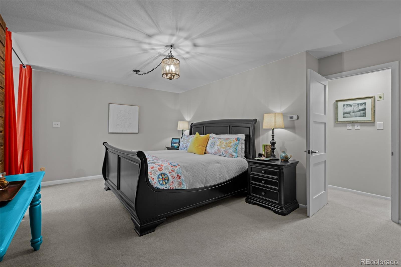 1 Rangeview Drive Wheat Ridge, CO 80215 - Photo 18 of 45 a bedroom with a bed and a chandelier