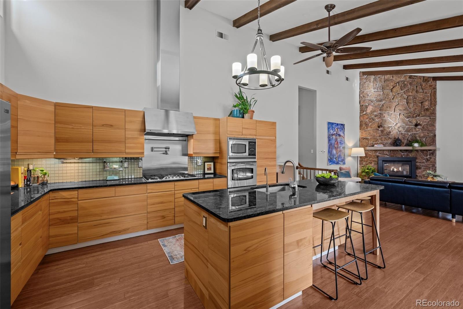 1 Rangeview Drive Wheat Ridge, CO 80215 - Photo 5 of 45 a kitchen with stainless steel appliances granite countertop a stove and a view of living room
