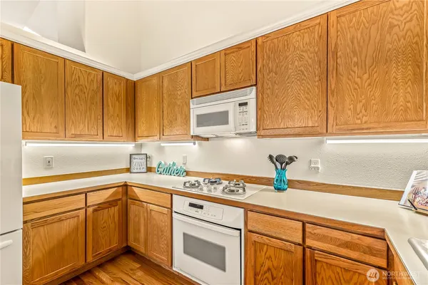a kitchen with stainless steel appliances granite countertop a sink a stove cabinets and granite countertops with wooden floor